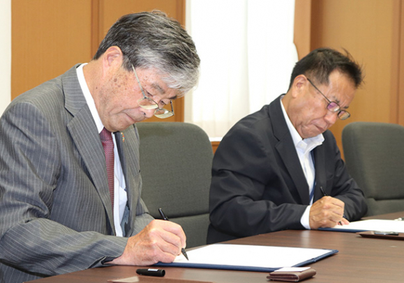 協定書に署名する江馬学長（左）と香田教育長＝揖斐川町役場で